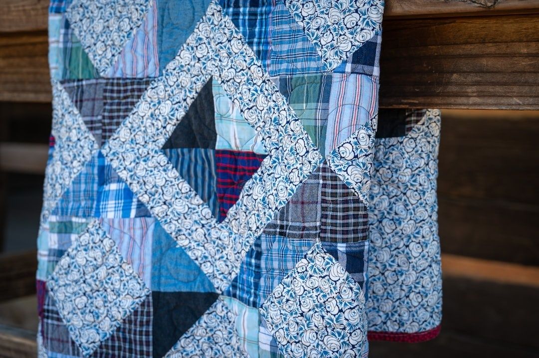 Blau-weißes Patchwork-Textil mit maritimen Mustern vor einer Holzwand