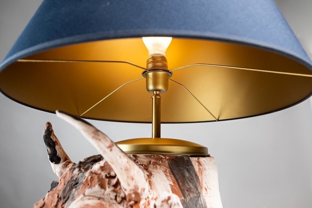 Rustikale Tischleuchte aus verwittertem Holz mit blauem Schirm und Messingdetails